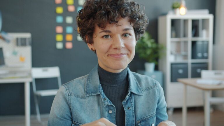 Casual portrait of a young adult in a modern office with vibrant decor.