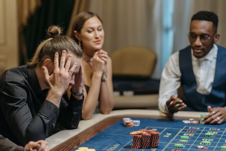 Tense and exciting moment at a casino roulette table with three diverse gamblers.